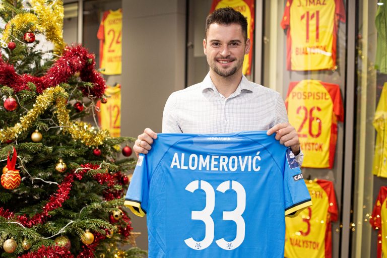 Nowy zawodnik Jagiellonii trzyma w rękach koszulkę ze swoim nazwiskiem