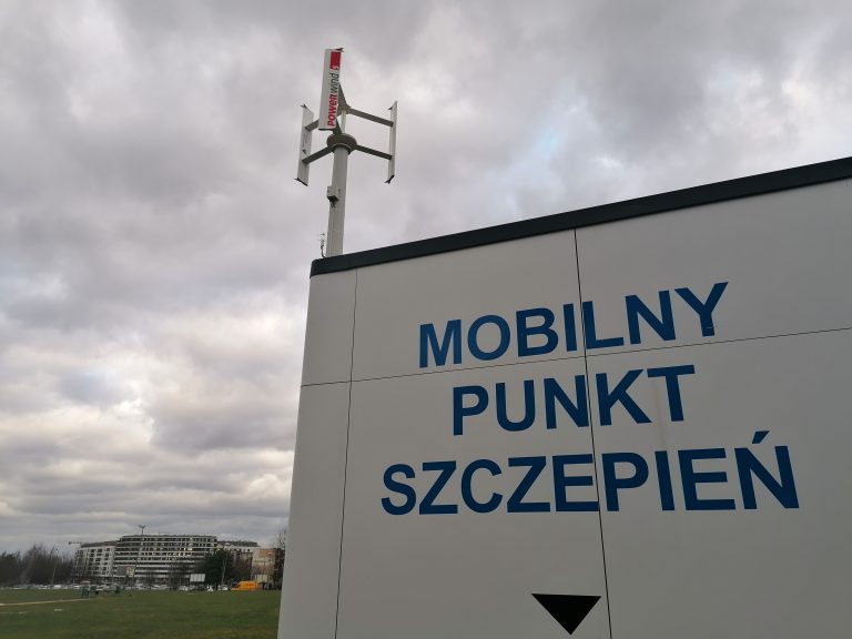 Napis "Mobilny punkt szczepień" na białym budynku