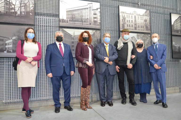 Ludzie na tle zdjęć wystawy modernistycznych budynków Kowna na wystawie na na Wydziale Architektury Politechniki Białostockiej