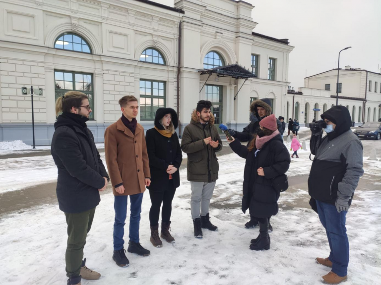 Młodzi ludzie stoją na terenie dworca PKP