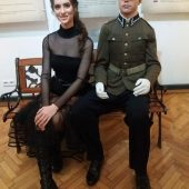 Kobieta siedzi obok figury żołnierza w muzeum wojska