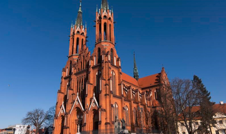 Zdjęcie fasady białostockiej katedry, która zbudowana jest z czerwonej cegły. Ma dwie wieże