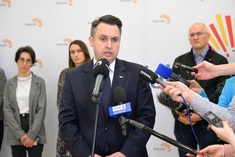 Mężczyzna mówi do mikrofonu podczas konfereencji prasowej