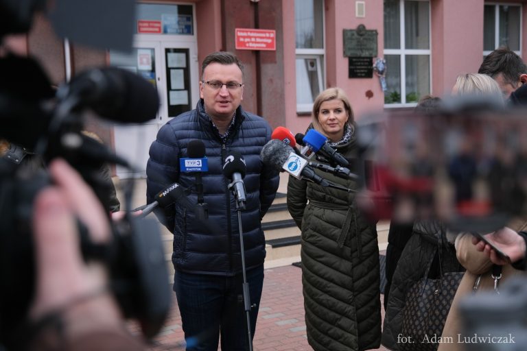 Konferencja prasowa przed budynkiem szkoły, do mikrofonu mówi wiceprezydent Białegostoku