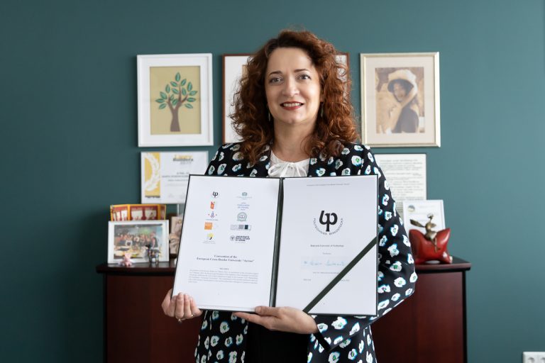 Rektor trzyma w rękach podpisane porozumienie