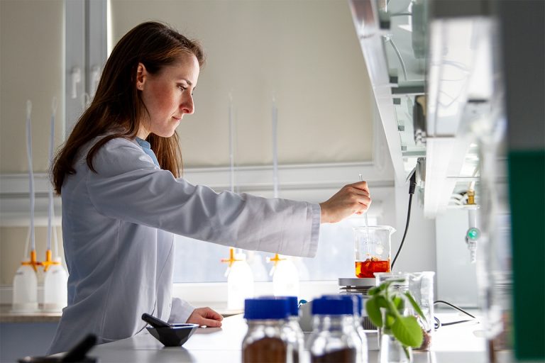 Młoda dziewczyna w białym kitlu w laboratorium