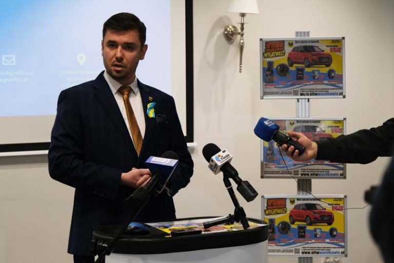 Mężczyzna stoi na konferencji prasowej