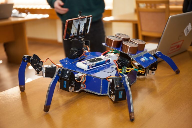 Robot w kształcie niebieskiego pająka stoi na biurku