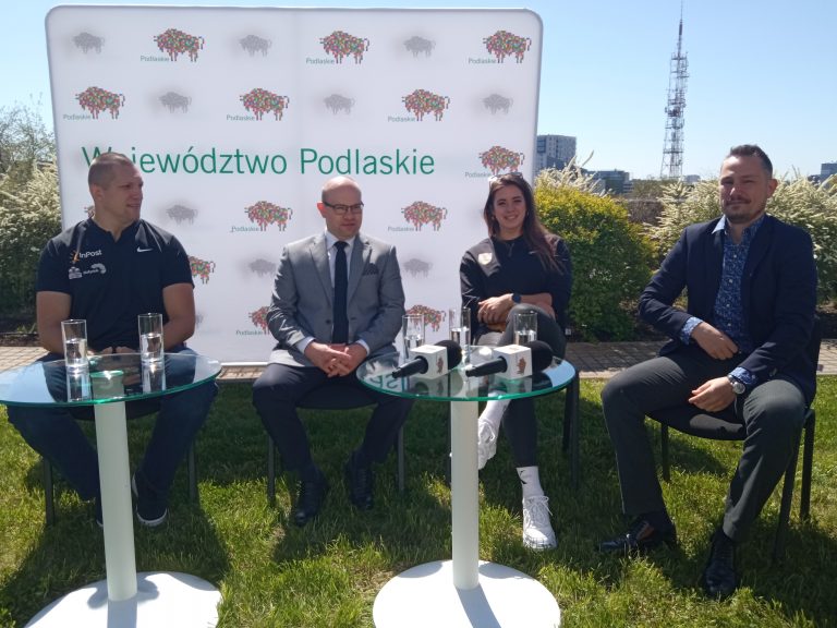 Przy stoliku podczas konferencji siedzą cztery osoby