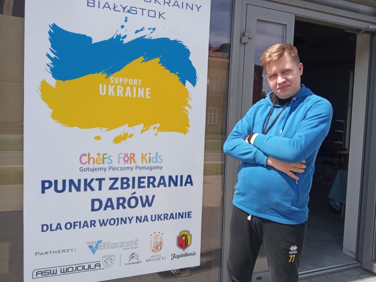 Mężczyzna stoi przed wejściem do budynku