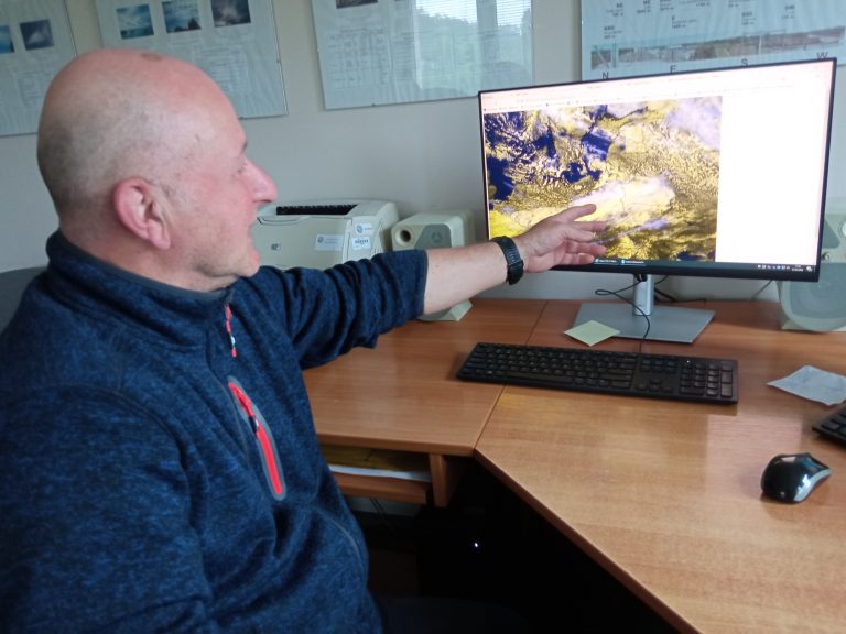 Mężczyzna pokazuje mapę pogody na ekranie komputera