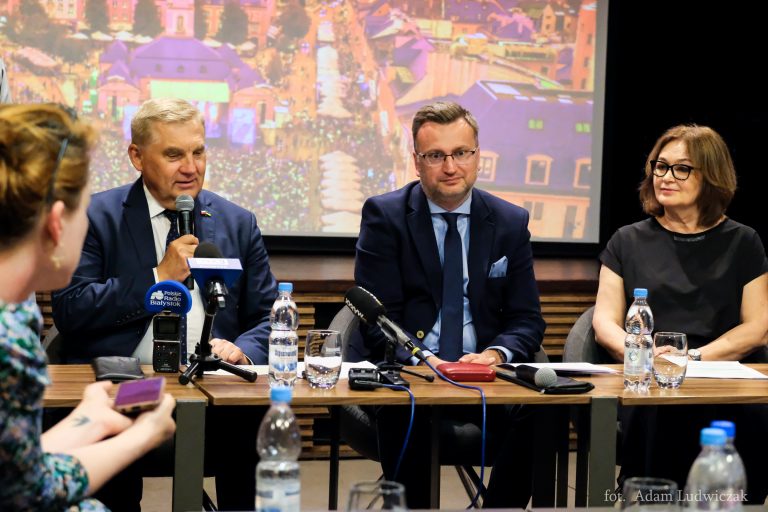 Przy stole siedzi kobieta i dwaj mężczyźni