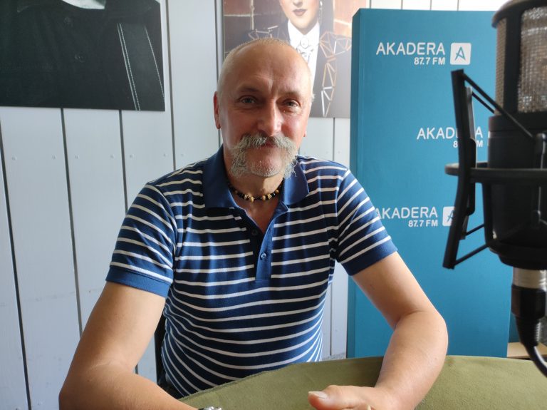 Mężczyzna z wąsem w radiowym studio
