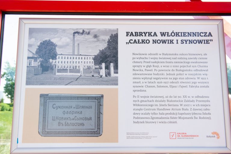 Tablica ze starym zdjęciem i tekstem na przystanku autobusowym