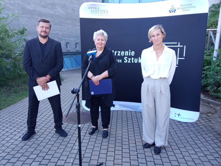 Diwe kobiety i mężczyzna stoją obok siebie na konferencji prasowej