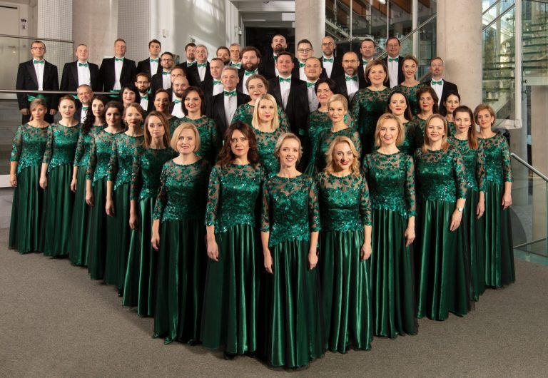 Chór kobiet i mężczyznw eleganckich jednakowych strojach