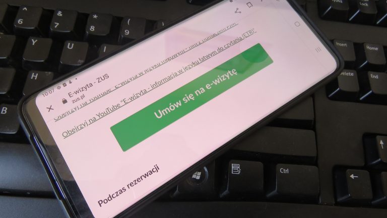 zielony przycisk "umów wizytę" widoczny na telefonie komórkowym