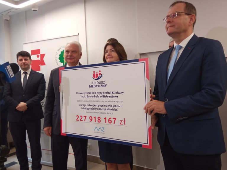 Konieta i mżężczyźni prezentują symboliczny czek przekazany dla szpitala