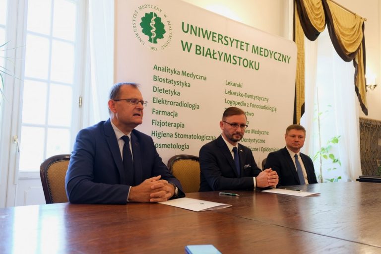 Trzech mężczyzn siedzi przy stole konferencyjnym