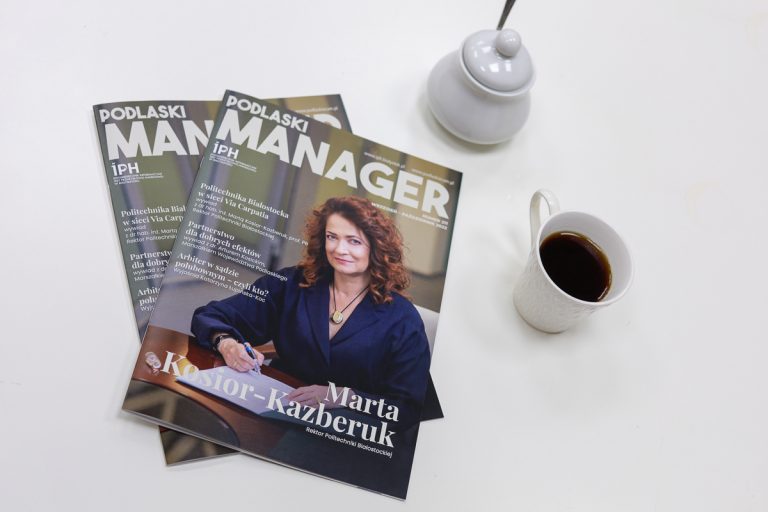Gazeta "Podlaski mengaer" leźy obok filiżanki kawy i cukierniczki