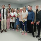 Pielęgniarki, lekarze oraz młodzi mężczyźni finalistści konkursu Mister Podlasia stoją w holu szpitala