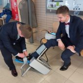 Dwóch uczniów pokazuje projekt urządzenie do rehabilitacji stawu skokowego