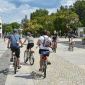 ludzie jadący na rowerach przez deptak Rynku Kościuszki