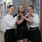 Trzy uczennice prezentują serduszka złożonych dłoni