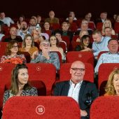 Ludzie siedzą w kinie.
