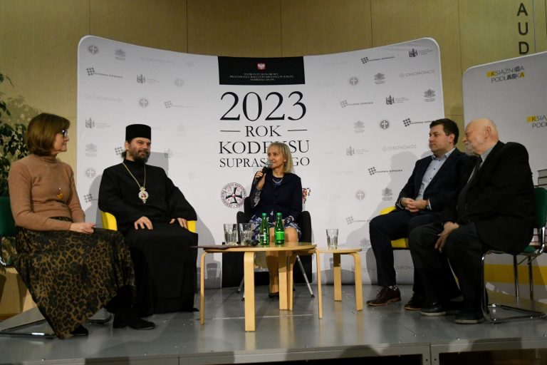 Ludzie siedzą wokół niskiego stolika.