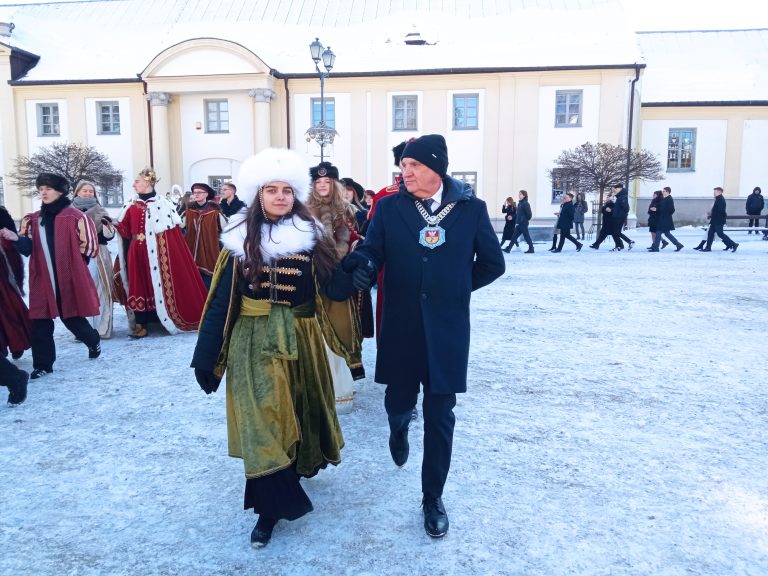 Młoda kobieta w historycznym stroju tańczy poloneza z mężczyną