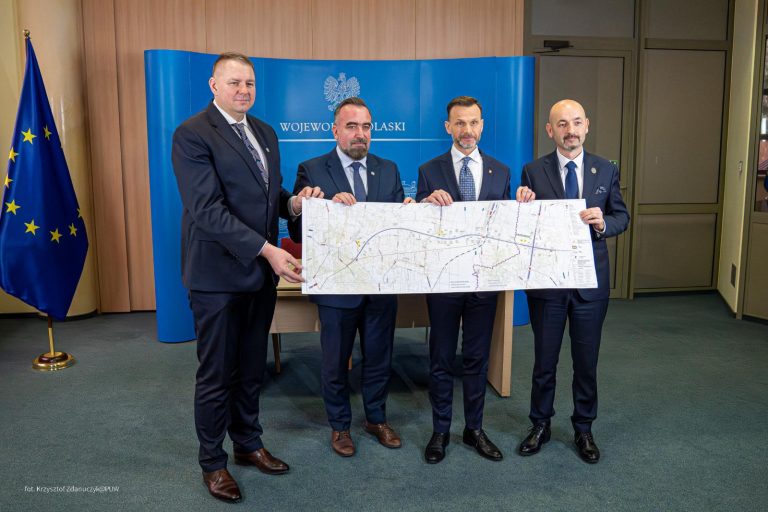 Czterech mężczyzn trzyma mapę.