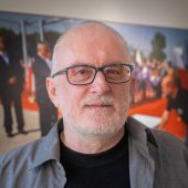 Mężczyzna na tle fotografii na ścianie.