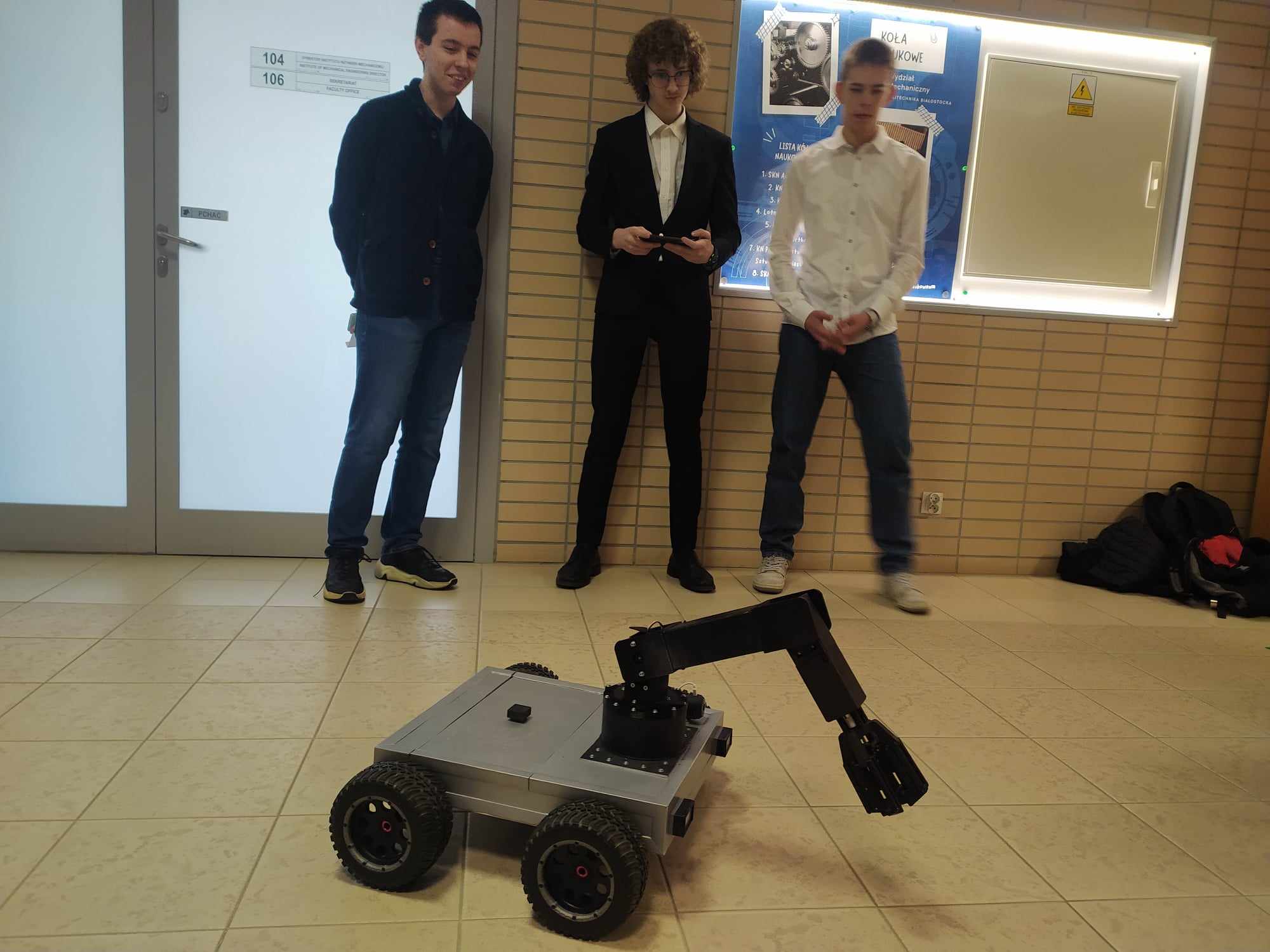 Trzech mężczyzn prezentuje łazika.