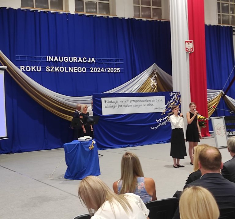Dziewczynki śpiewają przed publicznością podczas uroczystej inauguracji roku szkolnego.