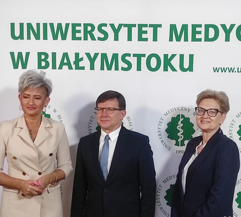 Uczestnicy konferencji pozują na ściance do zdjęć UMB.