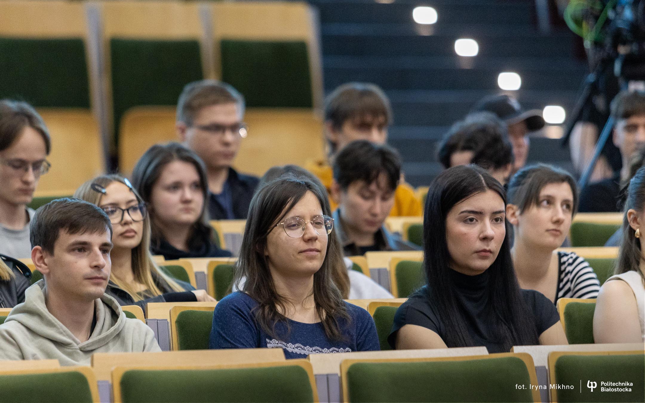 Ludzie siedzą w auli.
