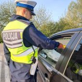 Policjant z alkomatem, kontroluje kierowce