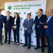 Na tle ścianki z napisem Uniwersytet Medyczny w Białymstoku, stoją elegancko ubrani ludzie, podczas konferencji prasowej. Na zdjęciu m.in. Rektor UMB w Białymstoku oraz Pani Dyrektor UDSK w Białymstoku.
