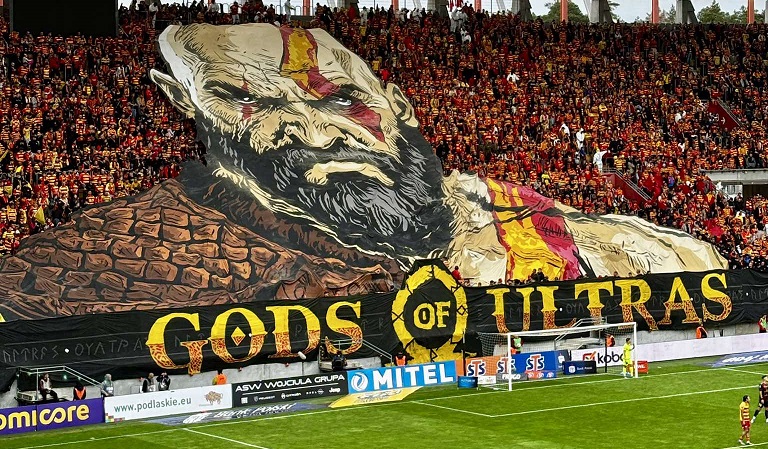 stadion pilkarski, oprawa kibicow gods od ultras, trybuny i fragment boiska na nim widac pilkarzy