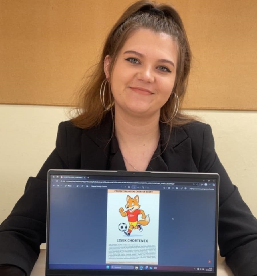 Dziewczyna pokazuje projekt maskotki liska na ekranie komputera.
