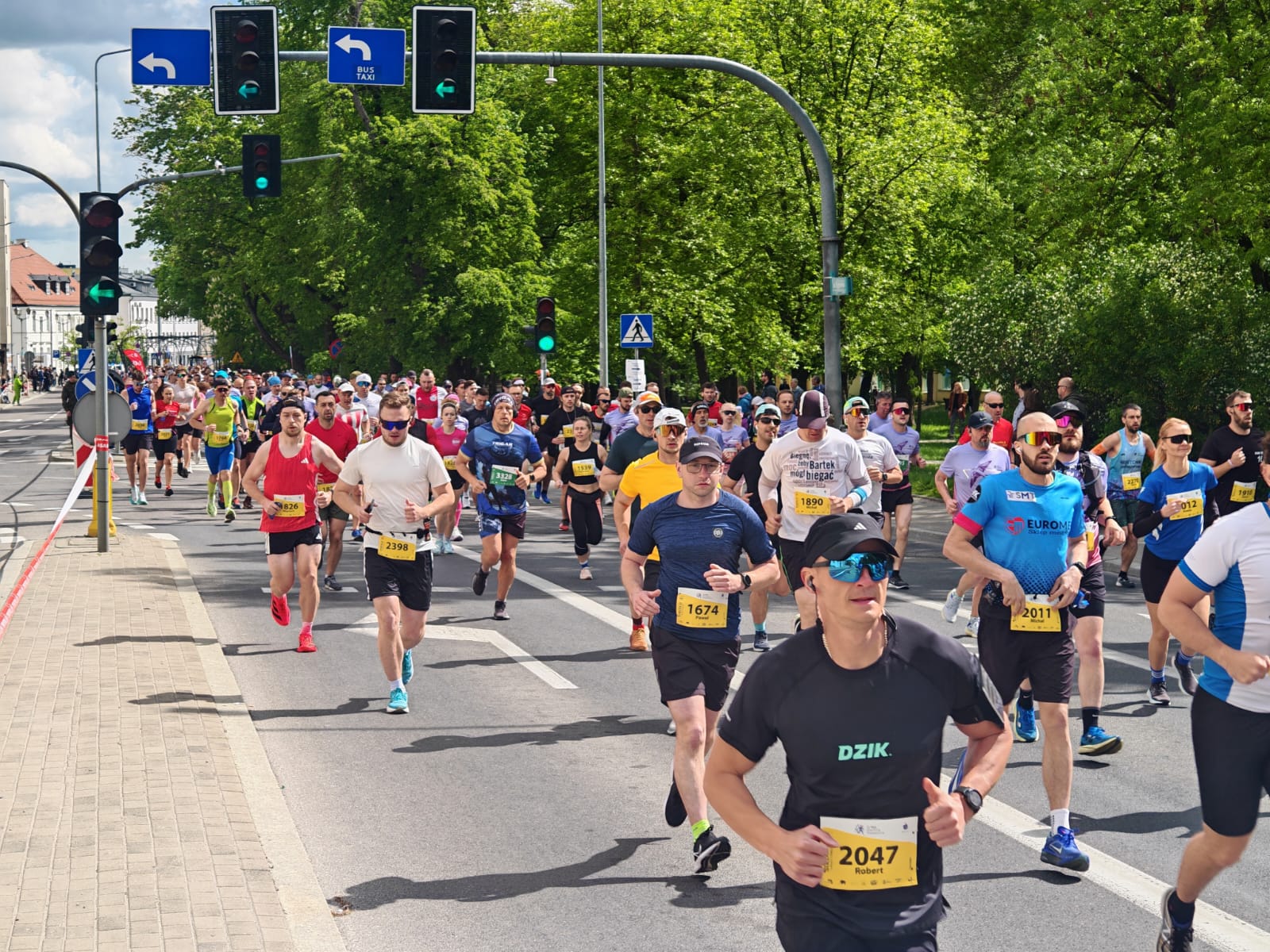 Biegacze biegną w półmaratonie asfaltową ulicą