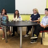Cztery kobiety – uczestniczki panelu dyskusyjnego – siedzą przy okrągłym stole podczas debaty o równości i inkluzywności. Jedna z nich mówi do mikrofonu. W tle tablica i jasnożółta ściana sali wykładowej Politechniki Białostockiej.