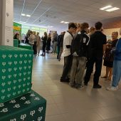 Korytarz uczelni stoja mlodzi ludzi, uczniowie, studenci, nauczyciele wykladowcy, na pierwszym planie widac logotypy Politechniki Bialostockiej, trwa przerwa przed wykladem