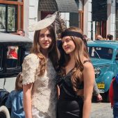 Modelki w stylizacjach na lata 20. i 30. XX wieku, pozują na tle retro aut.