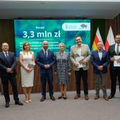 Ludzie pozują do zdjęcia na konferencji.