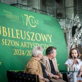 Trzy osoby siedzą na konferencji.