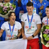 Sportowcy trzymają flagę.