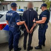 Dwóch policjantów trzyma mężczyznę.