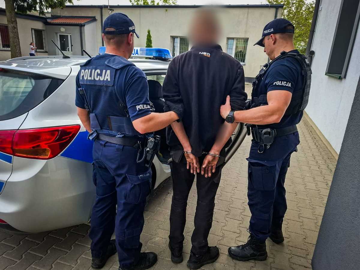 Dwóch policjantów trzyma mężczyznę.